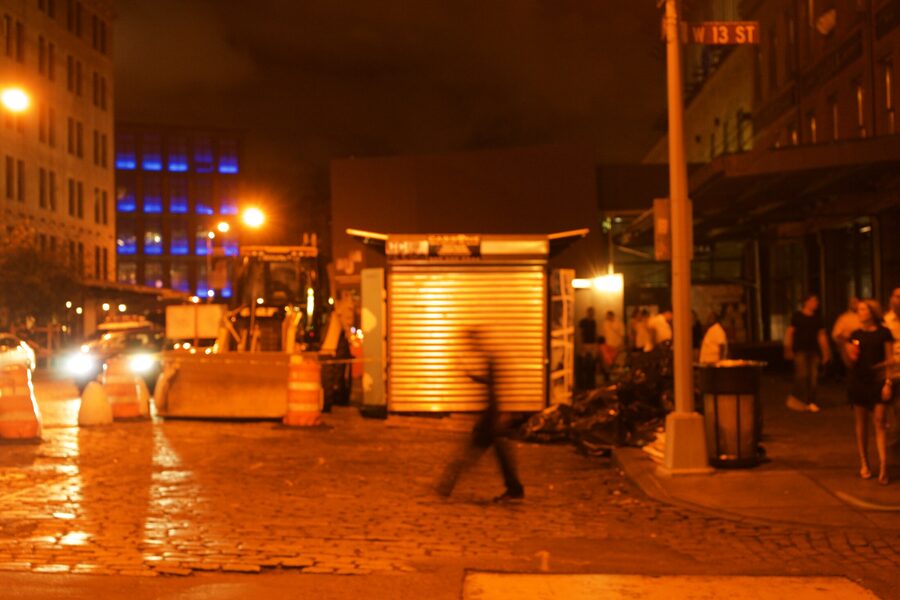 The same West 13th Street corner seconds later, the walking figure blurred mid-stride